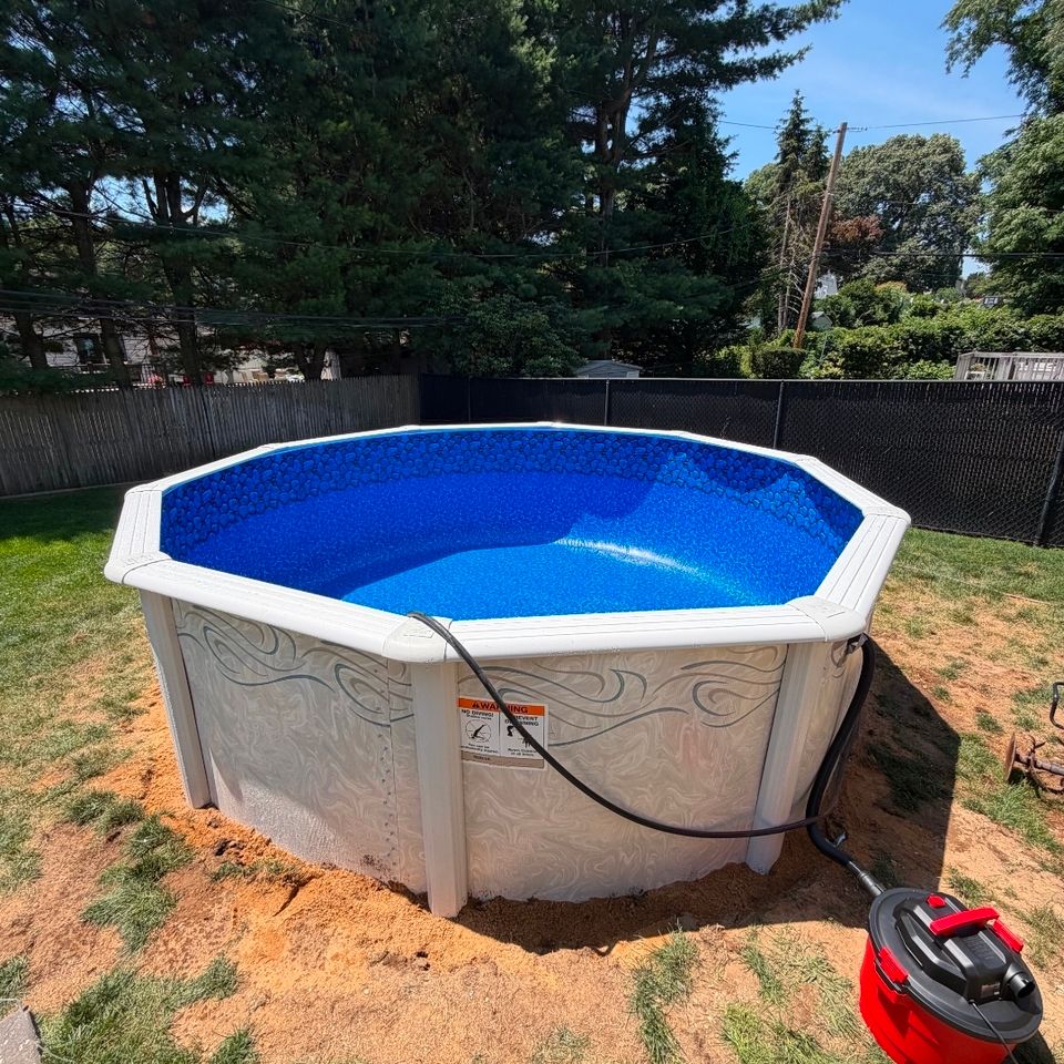 Round above ground pool installation with new liner and sand base in a Long Island backyard