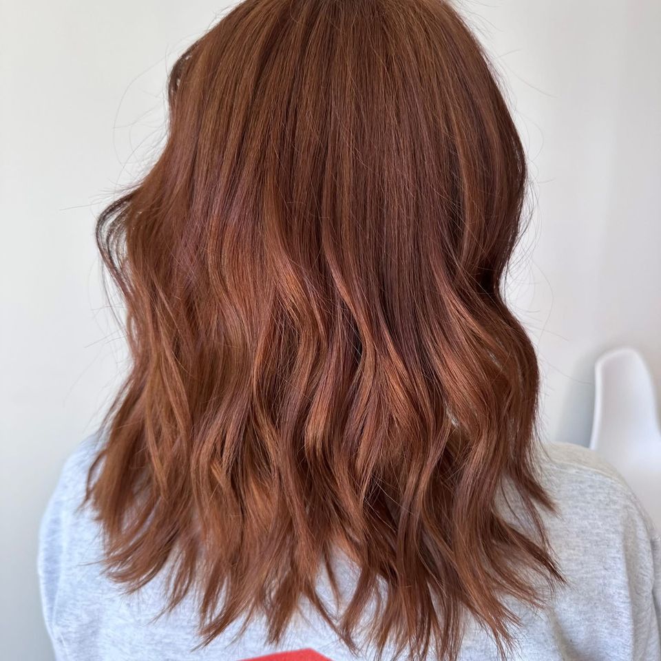 Medium length copper red wavy hair after vibrant color and styling in Columbiana AL