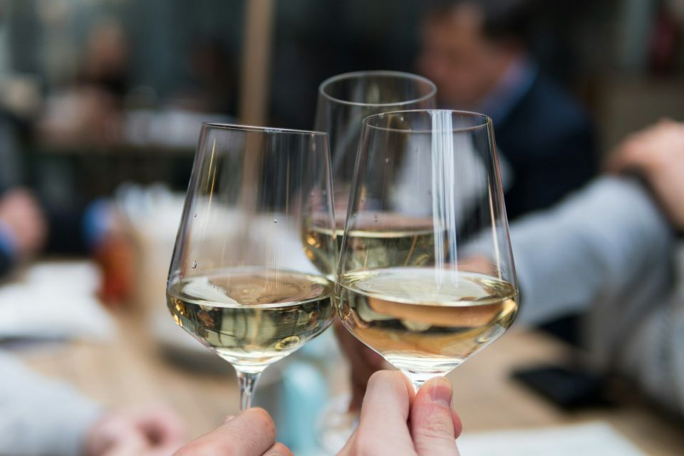 Three wine glasses toasting at an event.