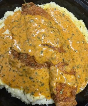 Fried catfish over creamy grits topped with a spicy creole sauce