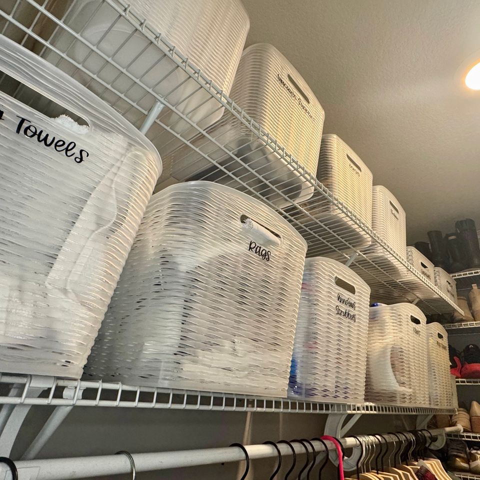 towels in bins and hampers with shoes and hangers in a closet