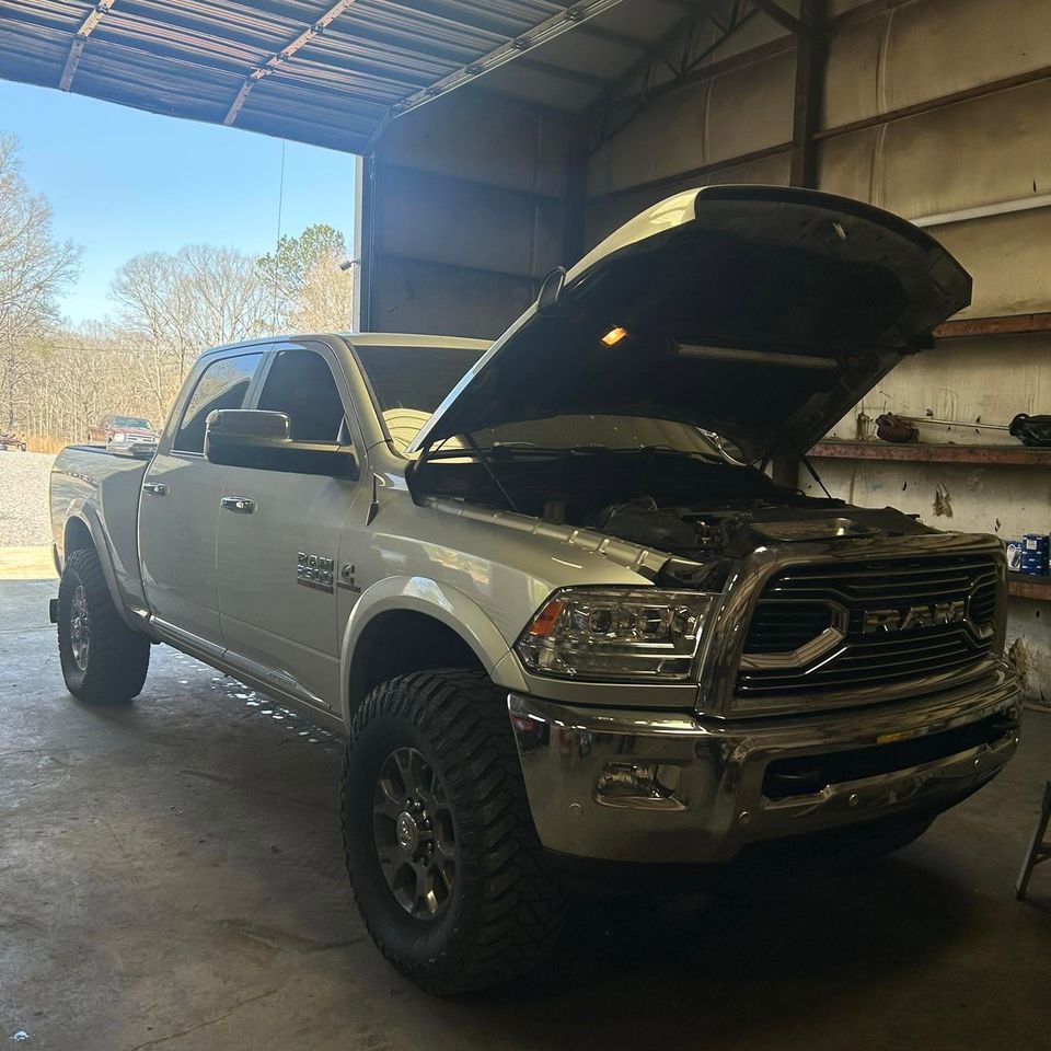 White Ram 2500 diesel truck with hood open inside truck repair shop in Arab Alabama