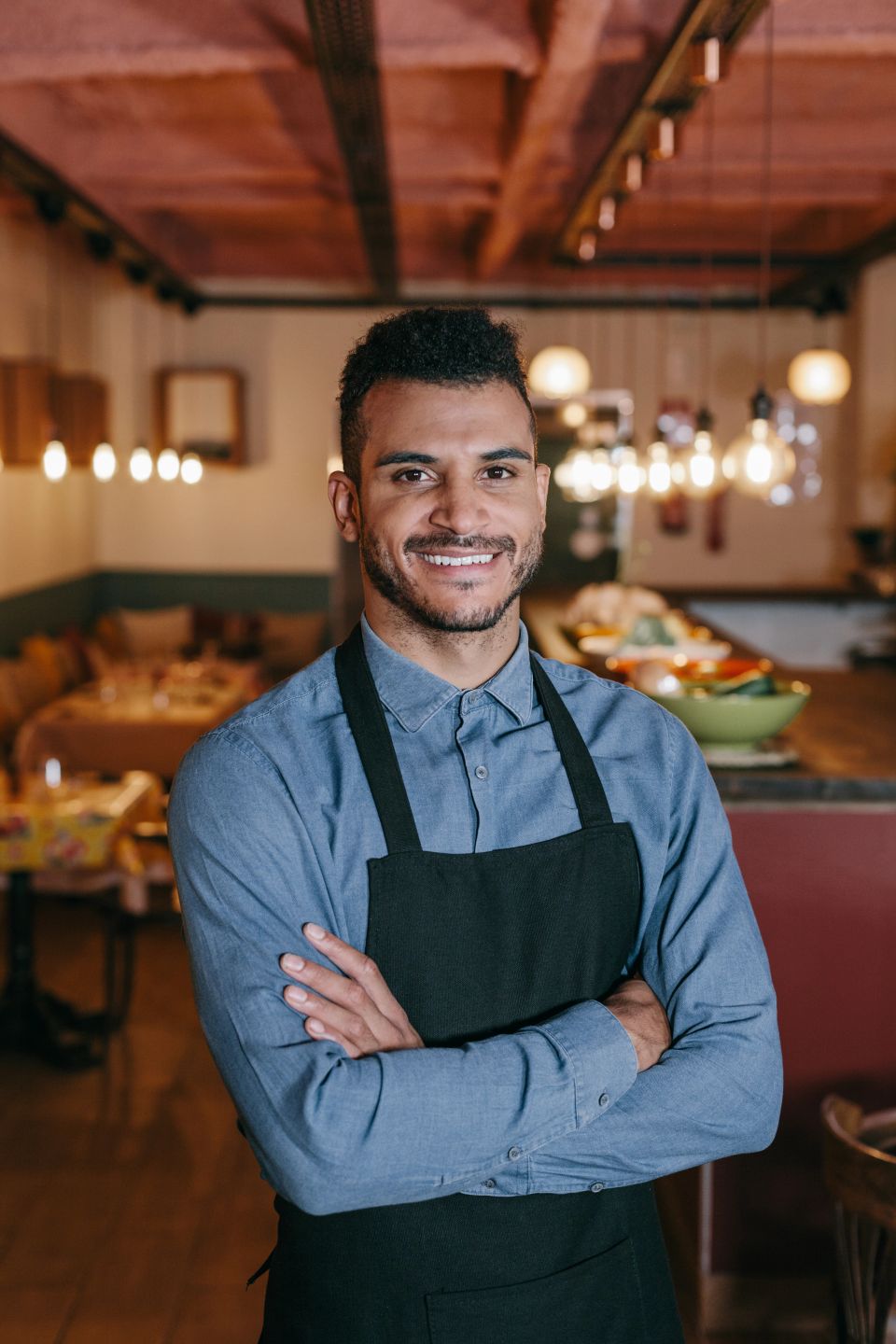 Restaurant owner with crossed arms proud by himself looking at camera