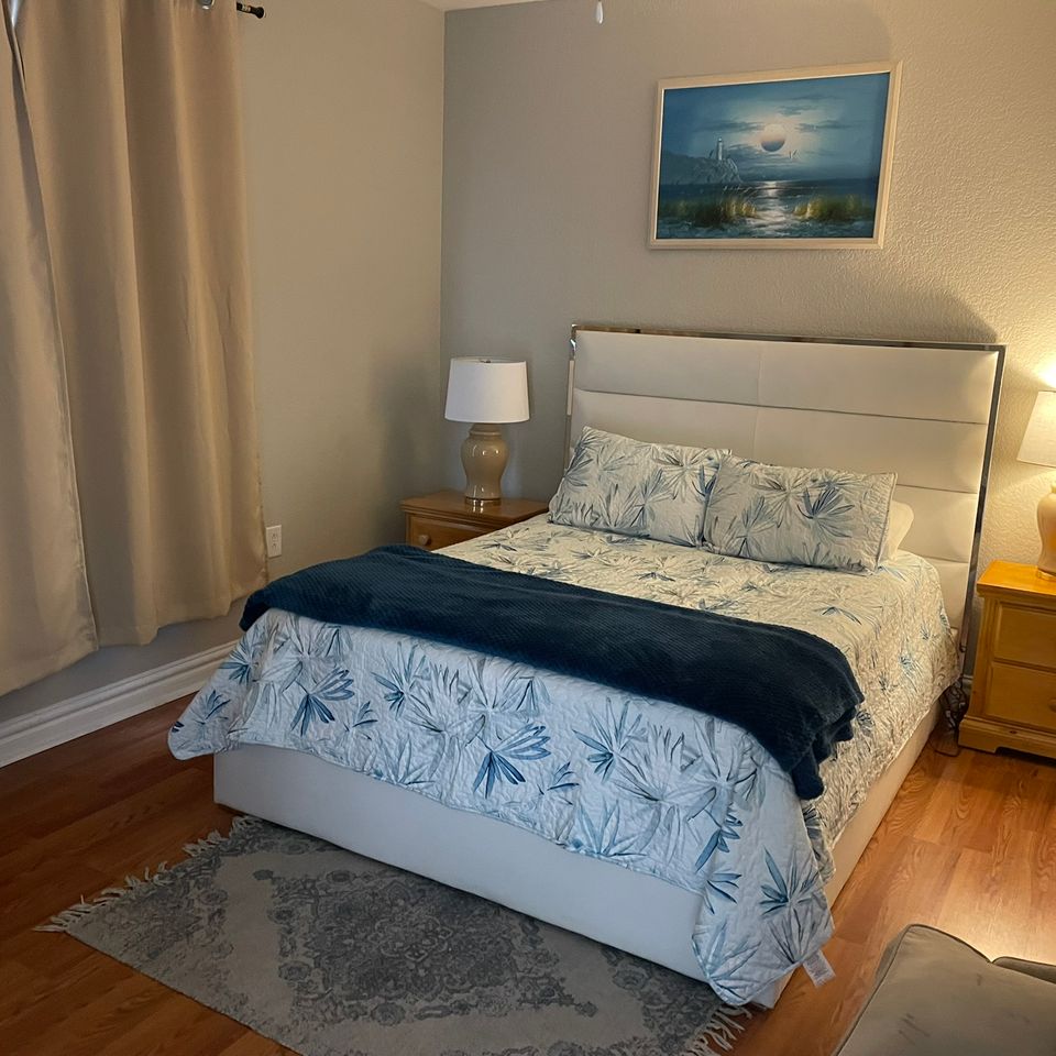 Made queen bed with nightstands in tidy bedroom after house cleaning service in Virginia Beach VA