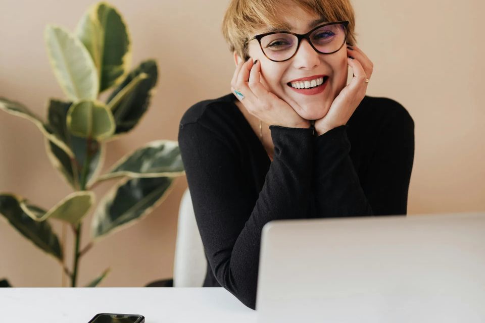 Woman with laptop happy about virtual therapy