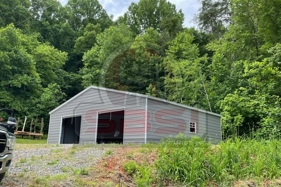 Gray steel garage with open bays on gravel lot with SBSI watermark representing steel garages in Alabama