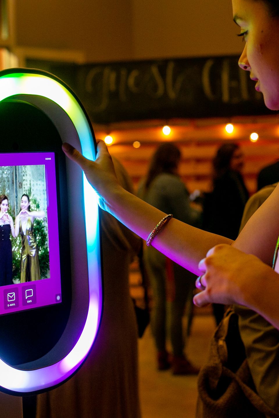 Close-up of a person using a colorful digital photo booth screen.