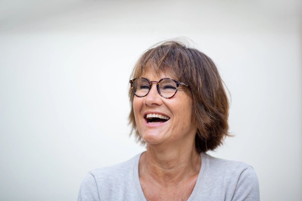 Close up portrait older woman laughing with eyeglasses against white background and looking away