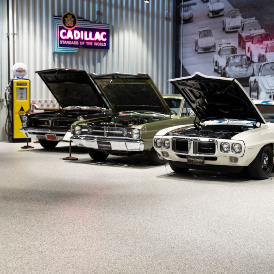Classic car showroom featuring EverStone Flakes flooring with vintage vehicles on display.