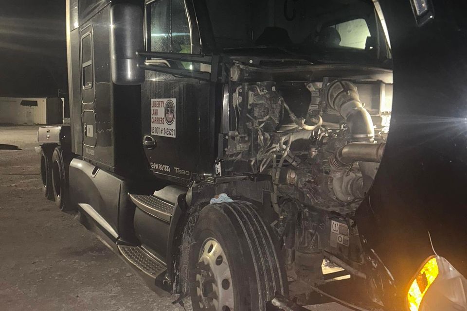 Black Kenworth T680 semi-truck with hood open for diesel engine repair at night in Arab Alabama