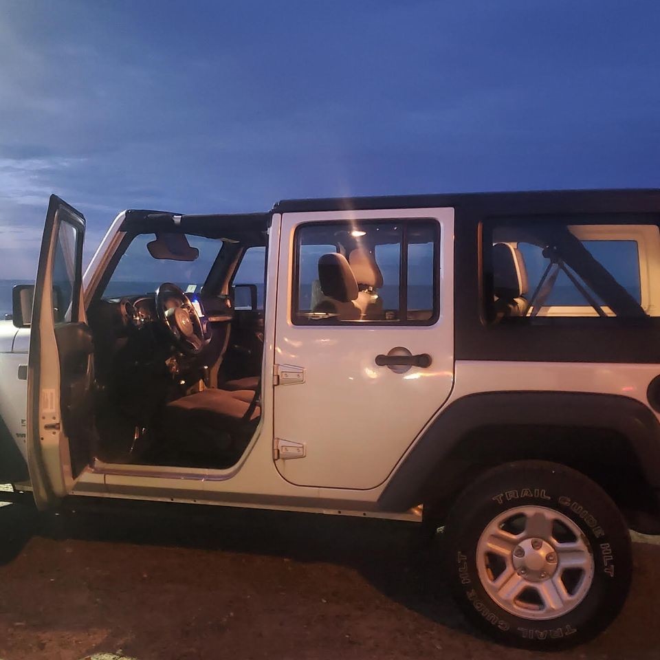 Pinnacle heights jeep grand cherokee side view front doors open at dusk boston beach backdrop