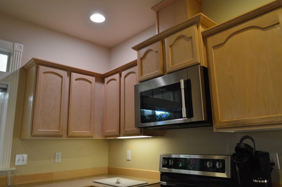 Kitchen with maple cabinets, stainless microwave, and under cabinet lighting in a custom home build