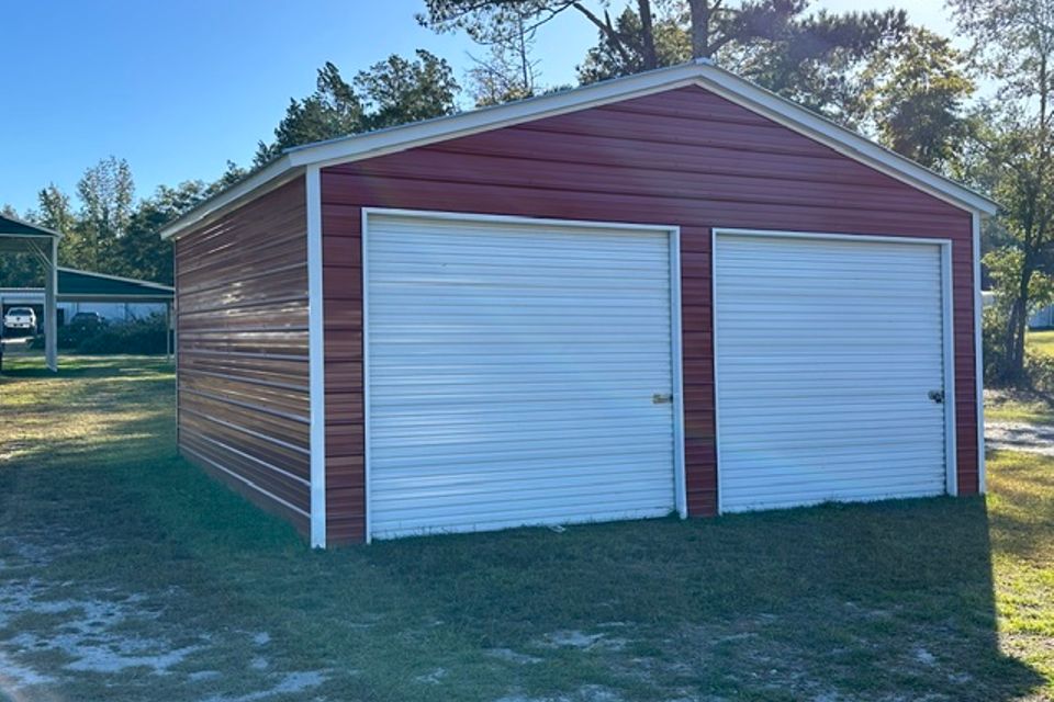Red and brown two car steel garage with white roll up doors representing steel garages in Alabama