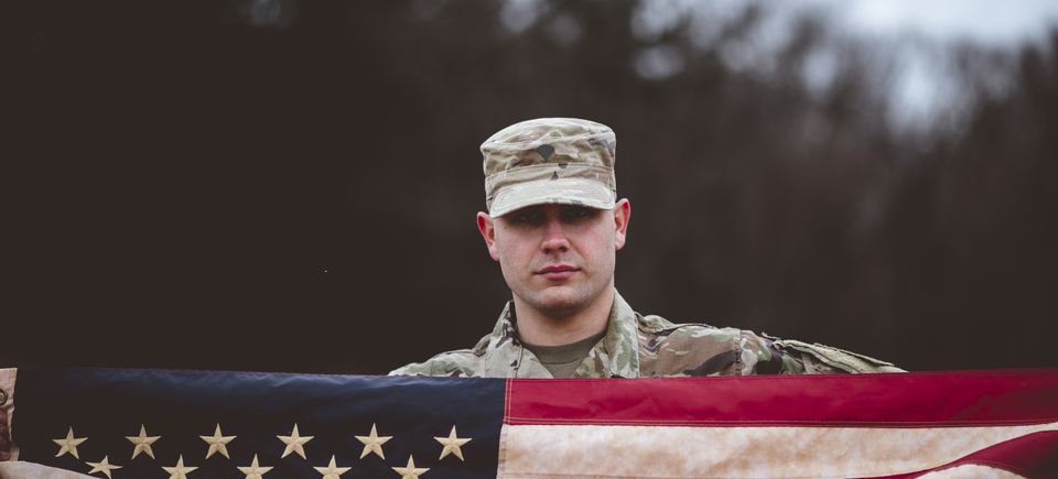 Shallow focus shot american soldier holding american flag