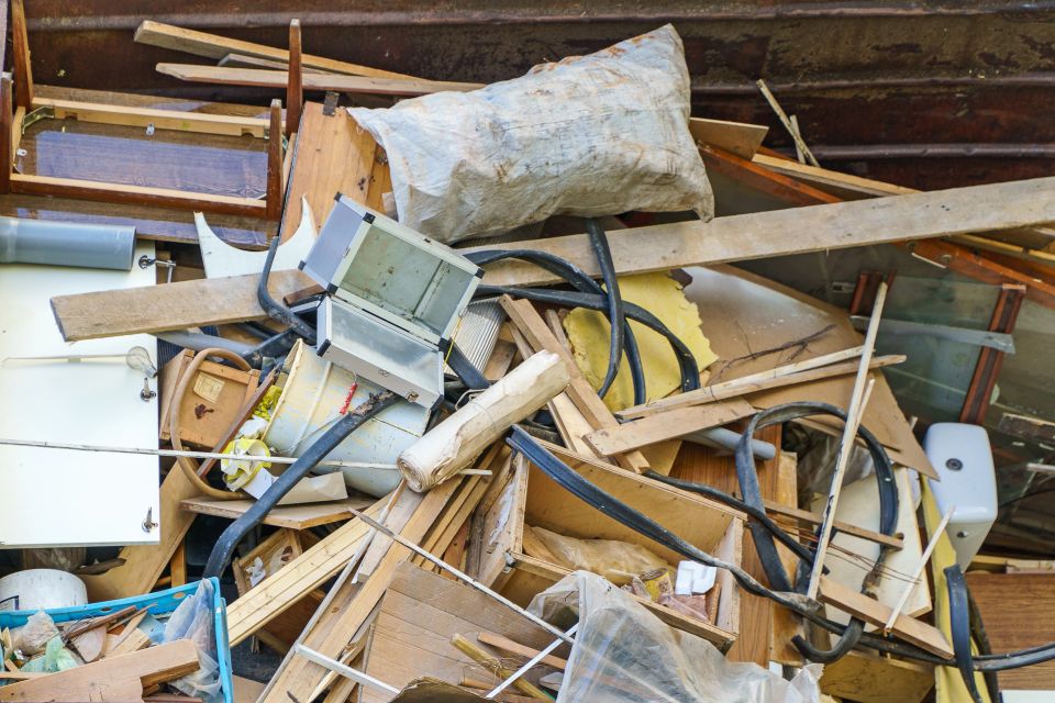 Many old home appliances and furniture in garbage container