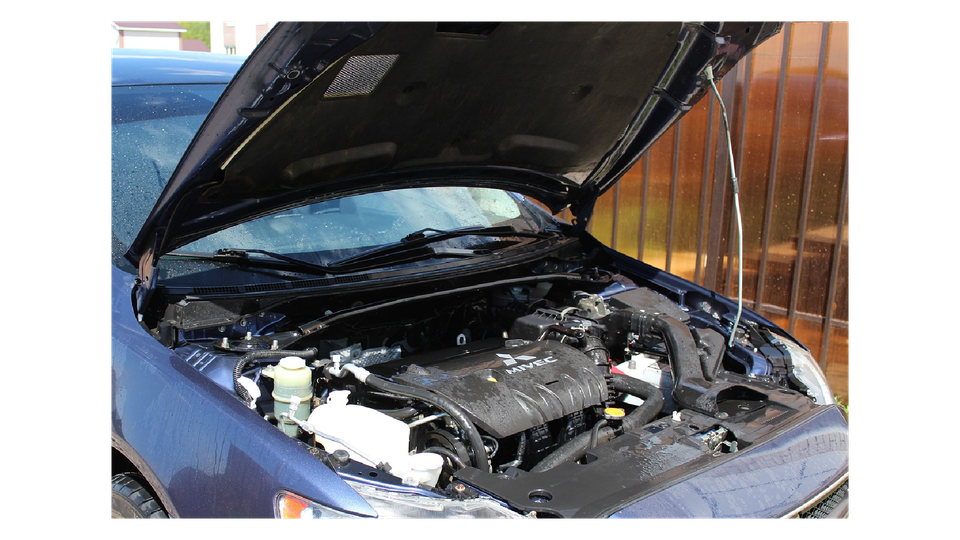 Image of engine compartment with hood up and rain getting the car wet.