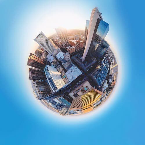 Aerial fish eye view of sky scrapers surrounded by a light blue background 