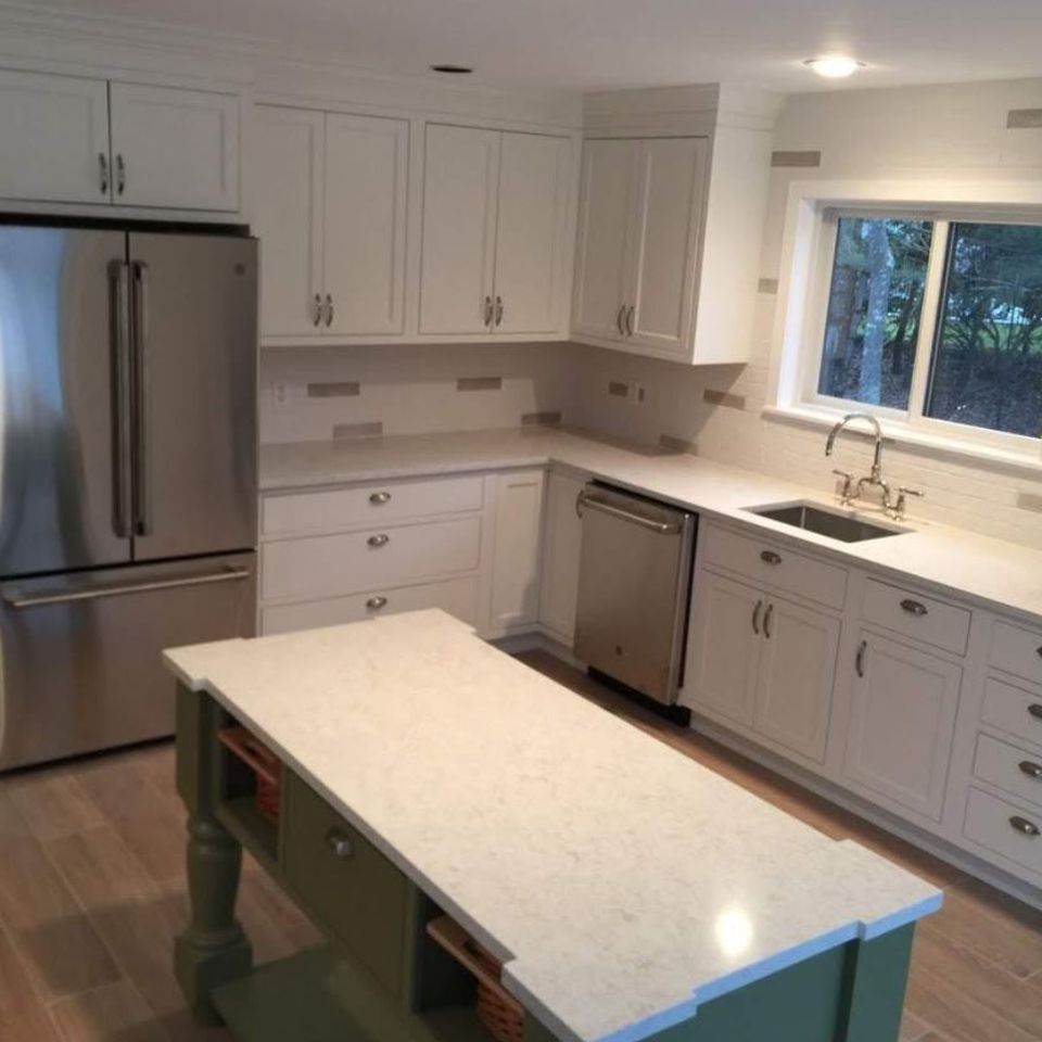 Remodeled kitchen with white cabinets and green island by general contractor in Suffolk County NY