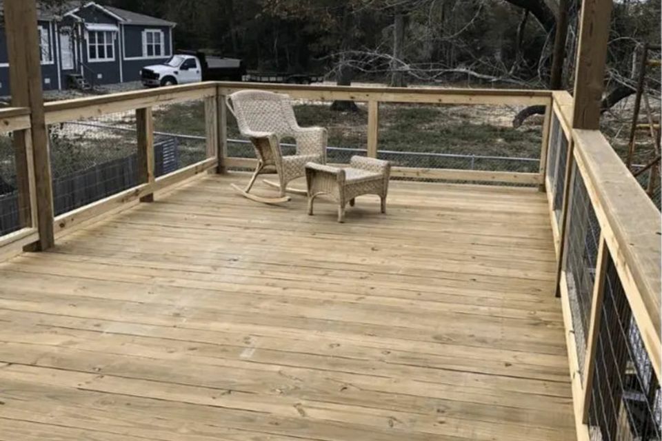 Raised wood deck with railing overlooking backyard