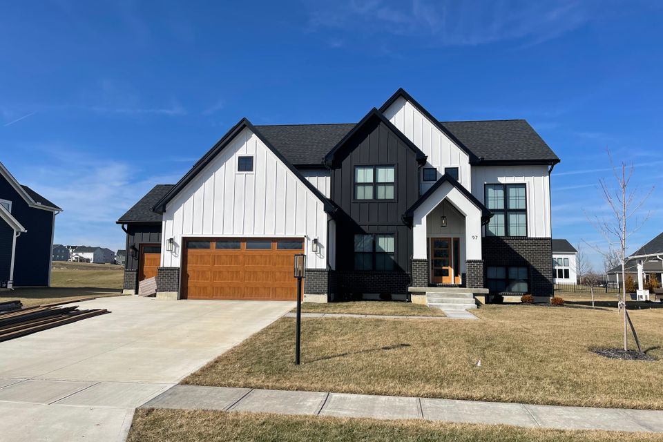 Two-story white and black home with a professionally installed dark gray architectural shingle roof by E & D Roofing, Inc.