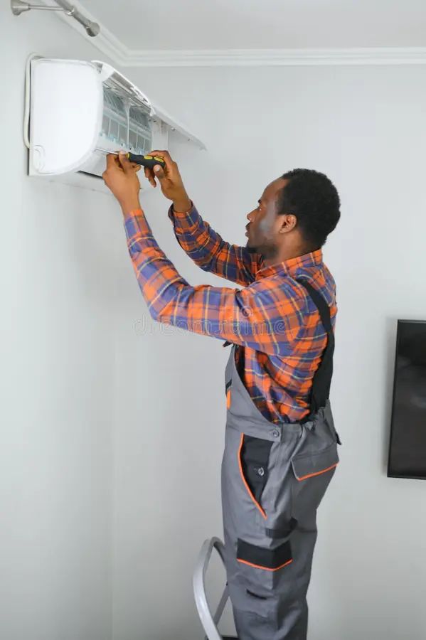 African american electrician repairing air conditioner indoors 306269502