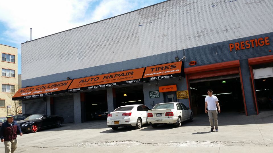 Long orange awning band with printed lettering across the front of an auto repair shop
