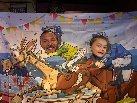 Adult and child posing in a Kentucky Derby horse racing photo booth during the event at JR's.