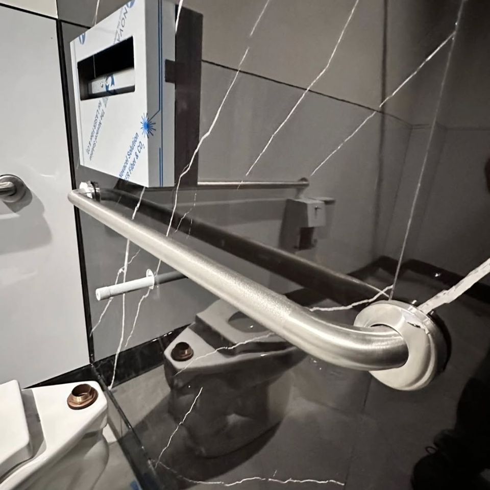 A handle bar in a bathroom partition done by Pabst Leyton in Southern California