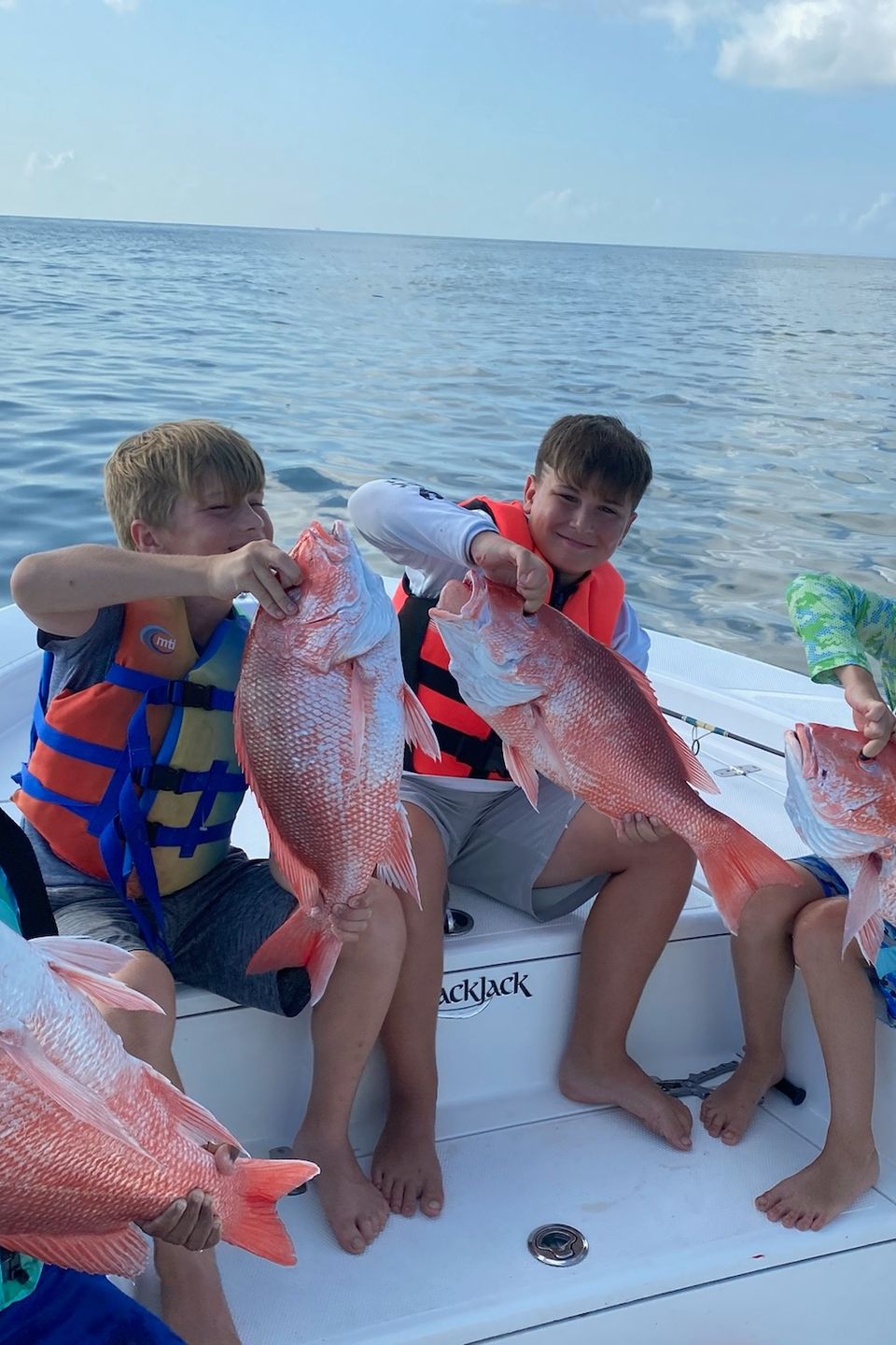 Kids proudly holding red snapper during a Carpe Diem Events fishing charter in Venice, Louisiana