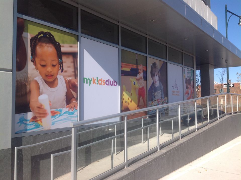 Printed vinyl window graphics with color photography and a logo covering a long glass storefront