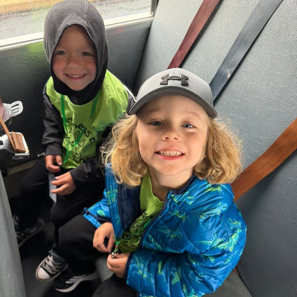 A school age boy and girl sitting in a school bus