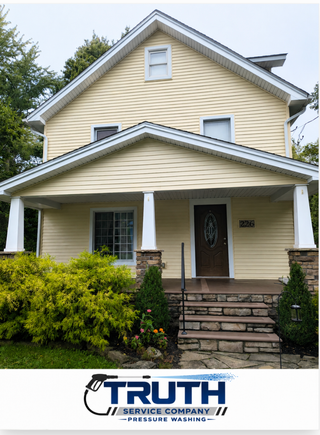 Clean home exterior with light-colored siding, a front porch, stone steps, and landscaped yard.