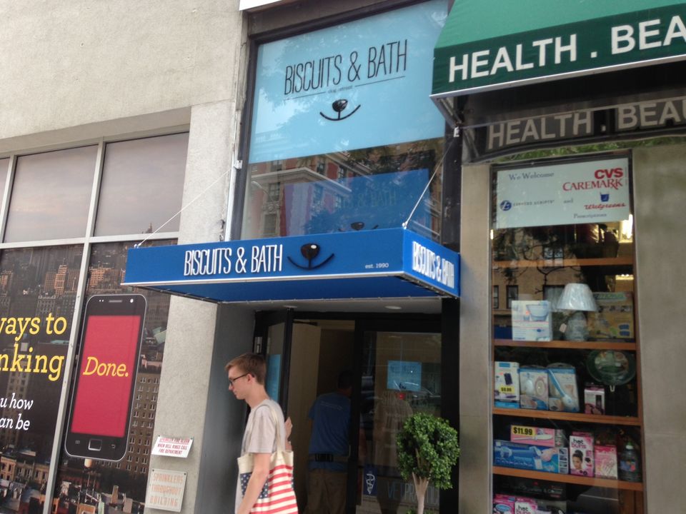 Blue storefront awning and matching entrance canopy with printed lettering on a Manhattan retail block