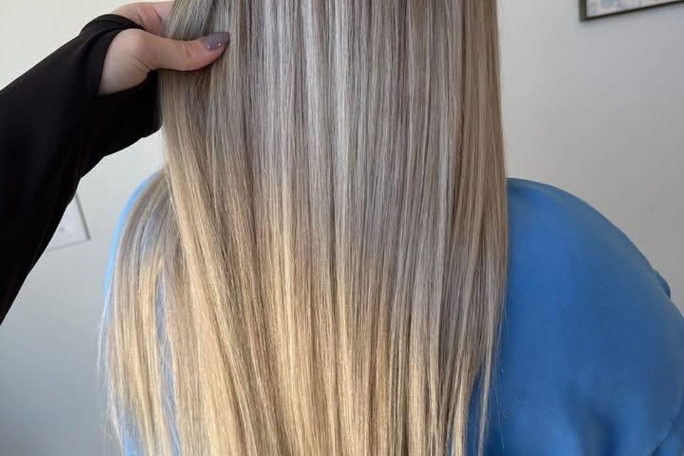 Long straight blonde balayage with soft dimension after color and styling in Columbiana AL