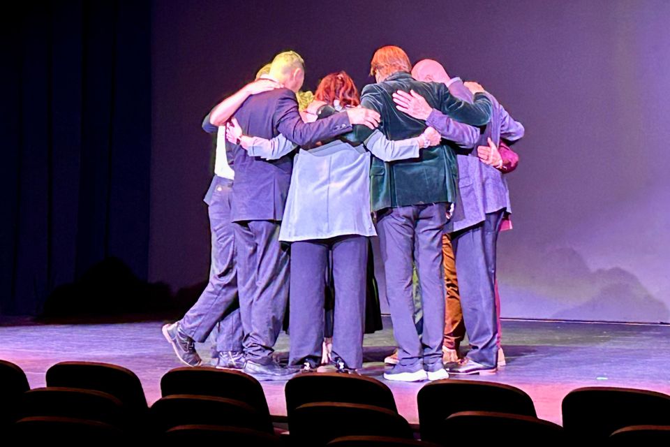 Group of people huddled on a stage