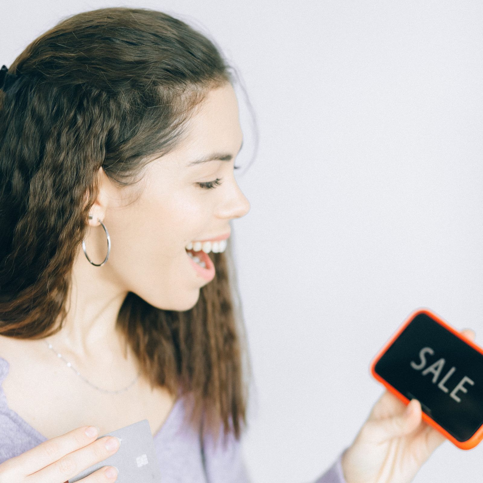 Excited shopper looking at a SALE text message offer on her phone