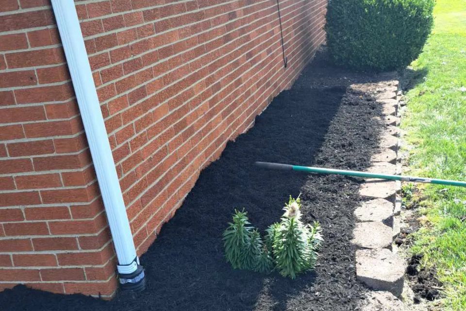 Decorative rock feature surrounded by freshly installed black mulch.