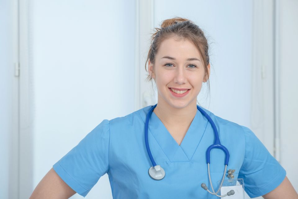 Female licensed nurse smiling, symbolizing the compassionate and friendly care provided by Elite On Demand.
