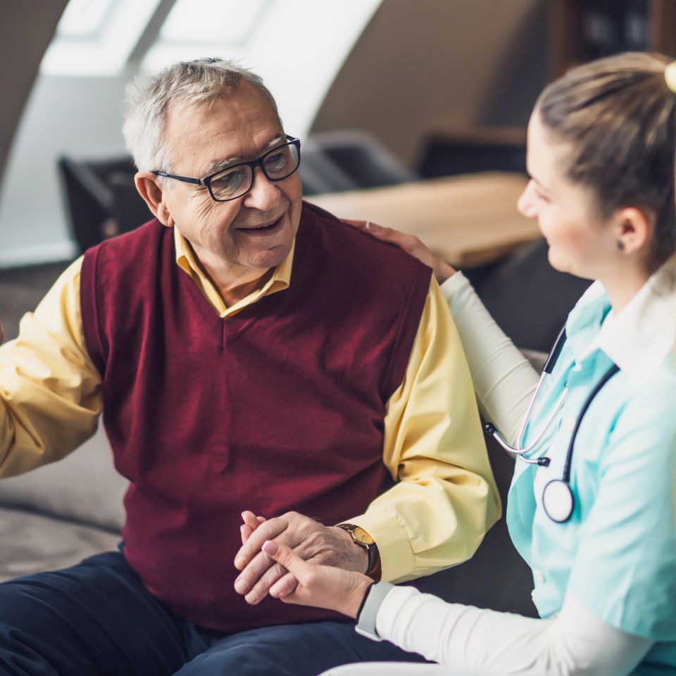 Nurse home caregiver is assisting old man at his home