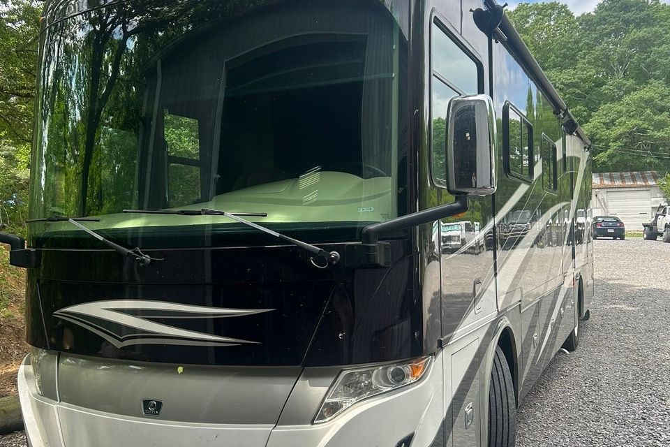 Black and tan Tiffin Class A motorhome parked at diesel repair shop in Arab Alabama