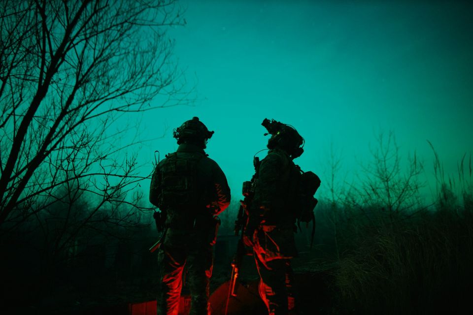 Image of paratroopers backlight by night sky