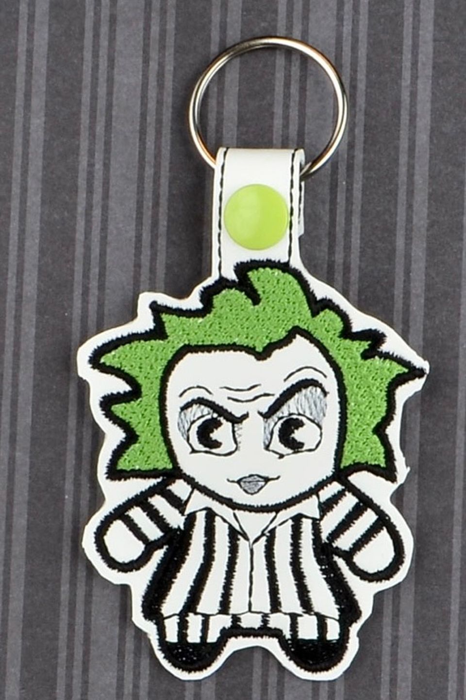 Custom embroidered character keychain with green hair, striped outfit, and cartoon-style embroidered details.