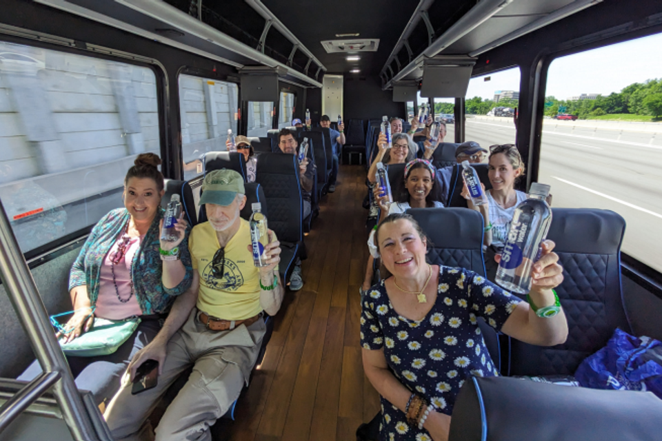 Group of individuals seated comfortably inside a tour bus, enjoying a vineyard tour