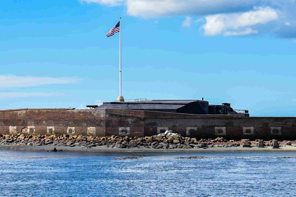 American flag flying over Fort Sumter surrounded by blue sky and sea