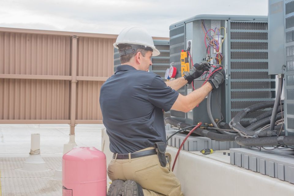 Technician checking condesing unit