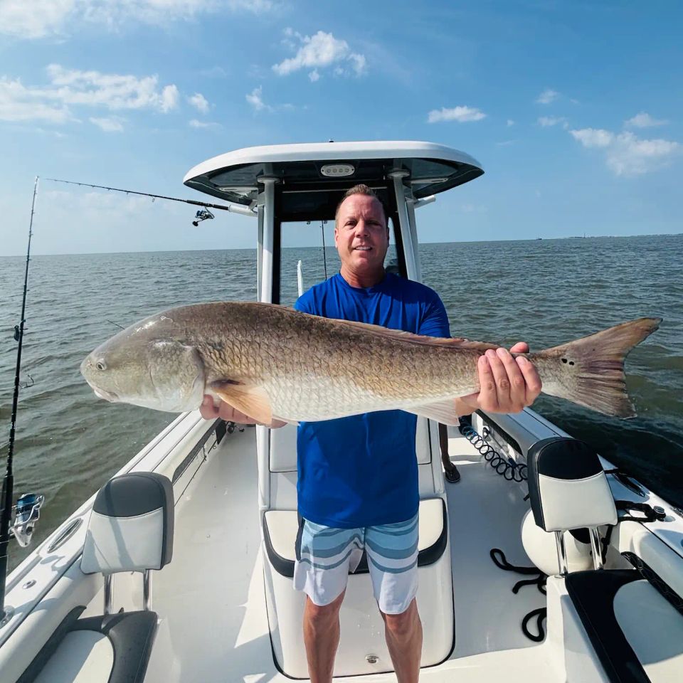 Angler holding a large redfish caught during a Charleston inshore fishing charter with LowCountry Coastal Excursions