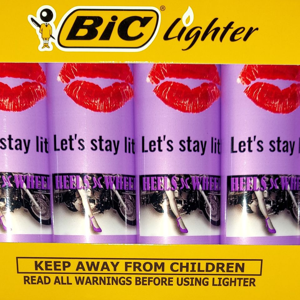 Display of custom purple Heels N Wheels BIC lighters featuring event branding and decorative graphics.