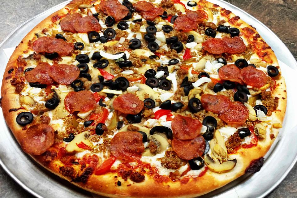 Cocca’s Deluxe Pizza topped with pepperoni, sausage, black olives, onions, and peppers.