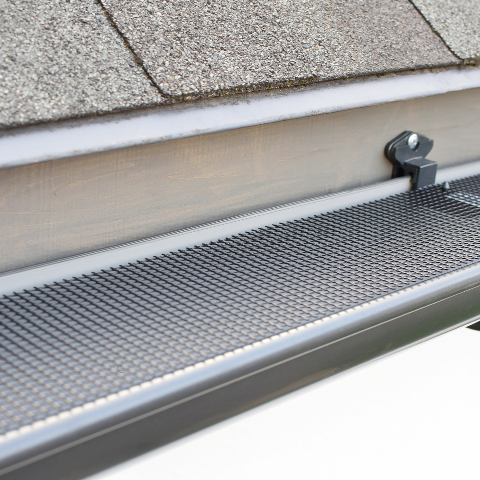 Close-up of a gutter guard system installed over a residential gutter to keep out leaves and debris.
