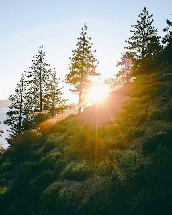 Sun peaking over a mountain on west shore of Lake Tahoe 